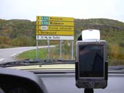 Der Benz vor einem Verkehrsschild auf welchem in Russischer Sprache Murmansk steht